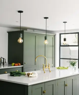 En idé om kjøkkenbelysning med downlights og pendler hang fra taket med dobbel høyde over brune skap