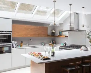 דוגמא לרעיונות למטבח בצורת U בעיצוב חיוור עם חלונות צוהר ובר ארוחת בוקר.