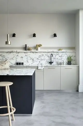 Arbeidsflate og bakplate i hvit marmor i hvitt oppsett med midnattsblå malt kjøkkenøy.