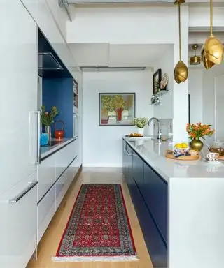Cocina blanca brillante con isla ktichen azul brillante y alfombra vintage