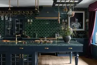 cucina verde con pentole e bicchieri appesi