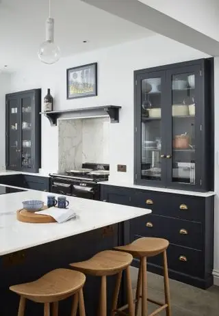 Cucina con mobili neri e pareti bianche che mostra come organizzare bene una cucina.