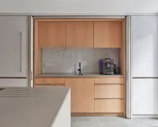 Riflet marmor kjøkken backsplash ideer omgitt av tre kjøkkenskap i et hvitt kjøkken