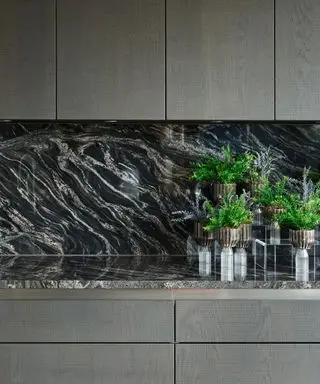 Et eksempel på marmorkjøkken-backsplash-ideer som viser et moderne kjøkken med en svart marmorbenk og backsplash