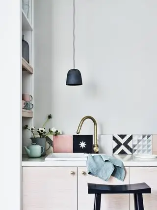 rosa og svarte fliser bak vasken i minimalistisk kjøkken