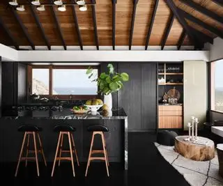 Cucina lunatica con un'isola da cucina nera sormontata da marmo bianco e nero