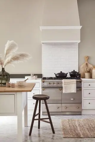 Idee per mobili da cucina dipinti di chiaro in uno schema beige chiaro con pavimento in marmo e alzatina piastrellata bianca.