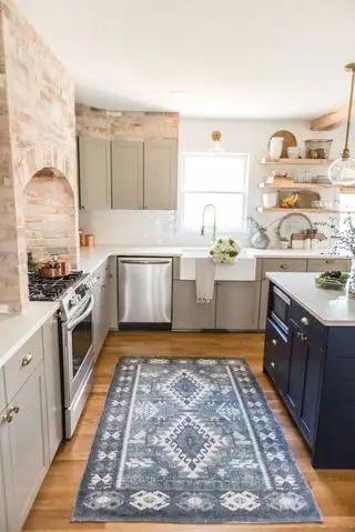 Idee per un mobile da cucina dipinto in grigio pietra chiaro e blu notte in una cucina rustica con pavimento in legno e pareti con mattoni a vista