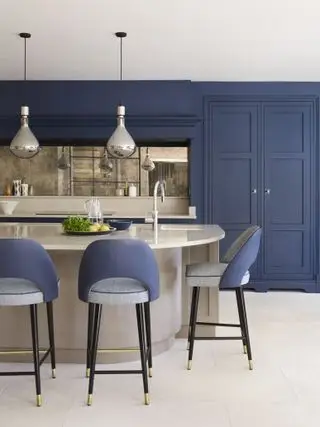 Idee per un mobile da cucina verniciato blu con un'isola verniciata grigia con bordi curvi e sgabelli da bar blu e grigi.
