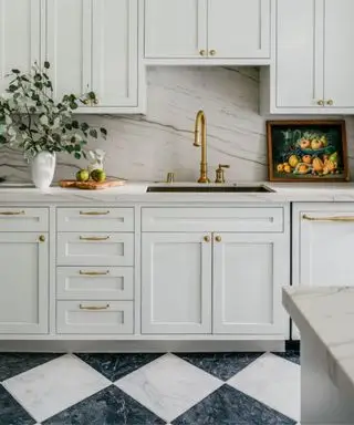 Cocina estilo shaker blanco neutro con suelo de mármol tipo tablero de ajedrez blanco y negro