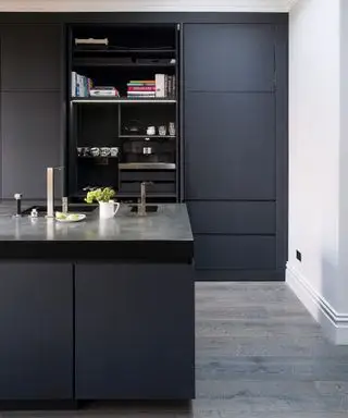 Uma cozinha moderna com armários pretos em azul escuro