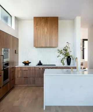 Moderne Küche mit Holzabzugshaube und weißen Wänden