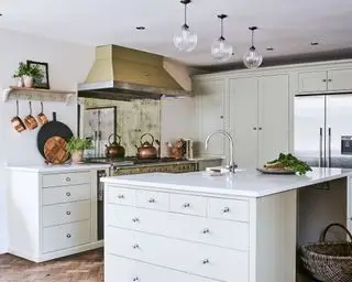 Traditionelle Küche mit Holzschrank und goldener Dunstabzugshaube