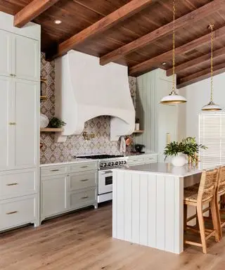 Landhausküche mit cremefarbenen Schränken und gemusterter gefliester Rückwand