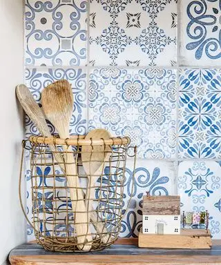 Rivestimenti da cucina con motivi blu e bianchi dietro una pentola di utensili