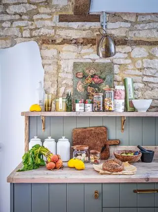 pantry med grå not- og fjærpanel med synlig steinmur og bjelker