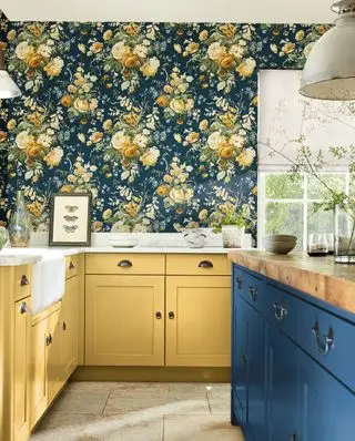 cozinha shaker com armários azuis e amarelos e papel de parede floral estampado