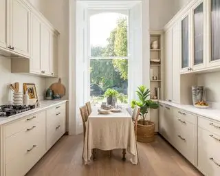 Cocina beige con gabinetes estilo Shaker y mesa tipo isla.