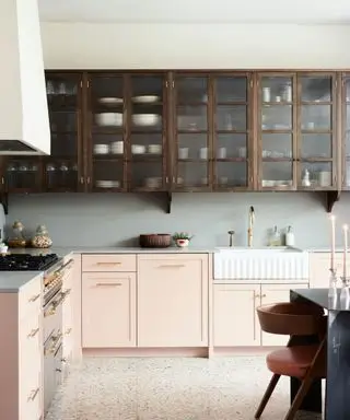 Cocina moderna de estilo rústico con gabinetes con frente de vidrio, fregadero estilo rústico y pintura de color neutro cremoso.