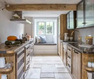 Cocina moderna de estilo rústico con techos bajos, armarios de madera y armarios superiores negros