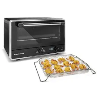 Un four de comptoir numérique KitchenAid avec Air Fry à côté d'un essai de crevettes frites sur fond blanc