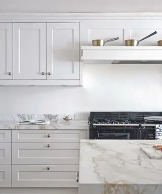 Una cocina blanca con encimeras de mármol.