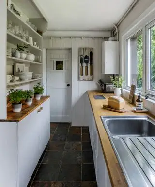 Ejemplo de cocinas de galera pequeñas en color blanco con encimera de madera.