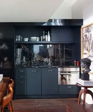 Cocinas de galera que se muestran en una cocina de galera individual azul medianoche con protector contra salpicaduras de granito negro.