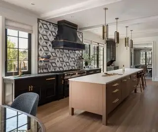 cocina con isla de madera y gabinetes contrastantes, placa para salpicaduras de azulejos geométricos con piso de madera