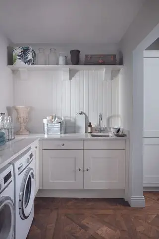 Et åpent vaskerom som leder inn til et kjøkken.
