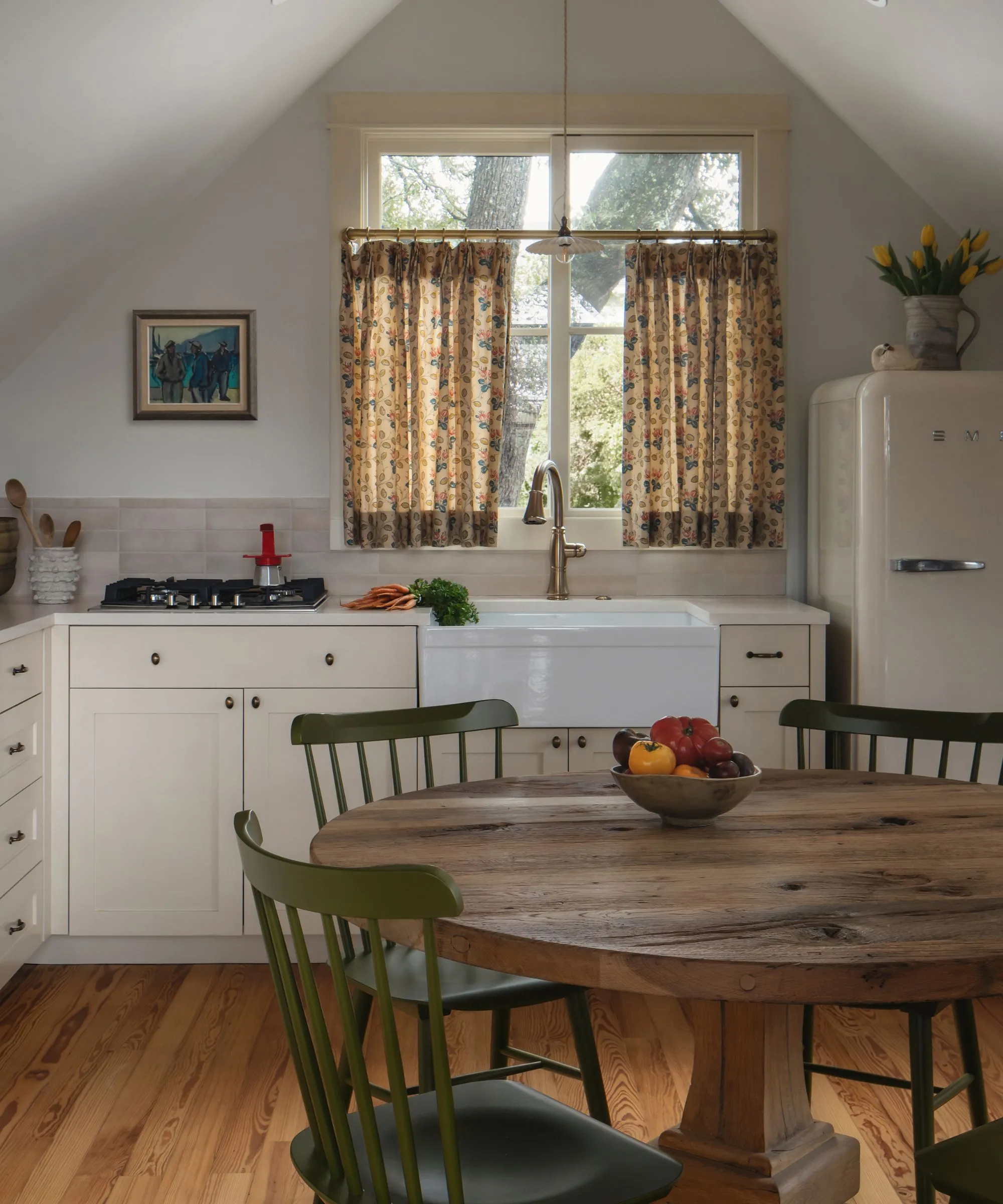 lille køkken med beige skabe og vægge og et sødt cafegardin' loading='lazy' title=