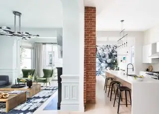 cucina stretta in uno spazio semi-open space, isola cucina lunga e stretta con lavello e bancone per la colazione, opere d'arte all'estremità
