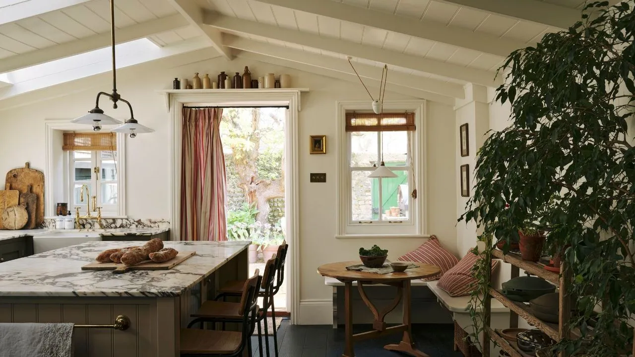 En ny køkkenudvidelse med hvælvede panellofter olivengrønne skabe marmorbordplader og et hyggeligt spiseområde' loading='lazy' title=