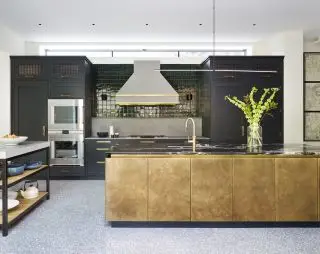 Et eksempel på moderne køkkenideer med mørkegrønt kabinet og bagplade og bladguld køkkenø.