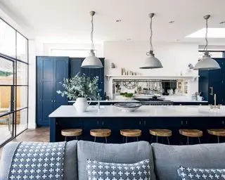 Moderne køkkenideer i blåt og hvidt, med en lang morgenmadsbar og pendelbelysning.