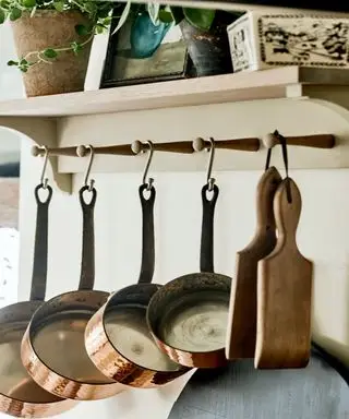 Pentole e padelle su ganci di legno