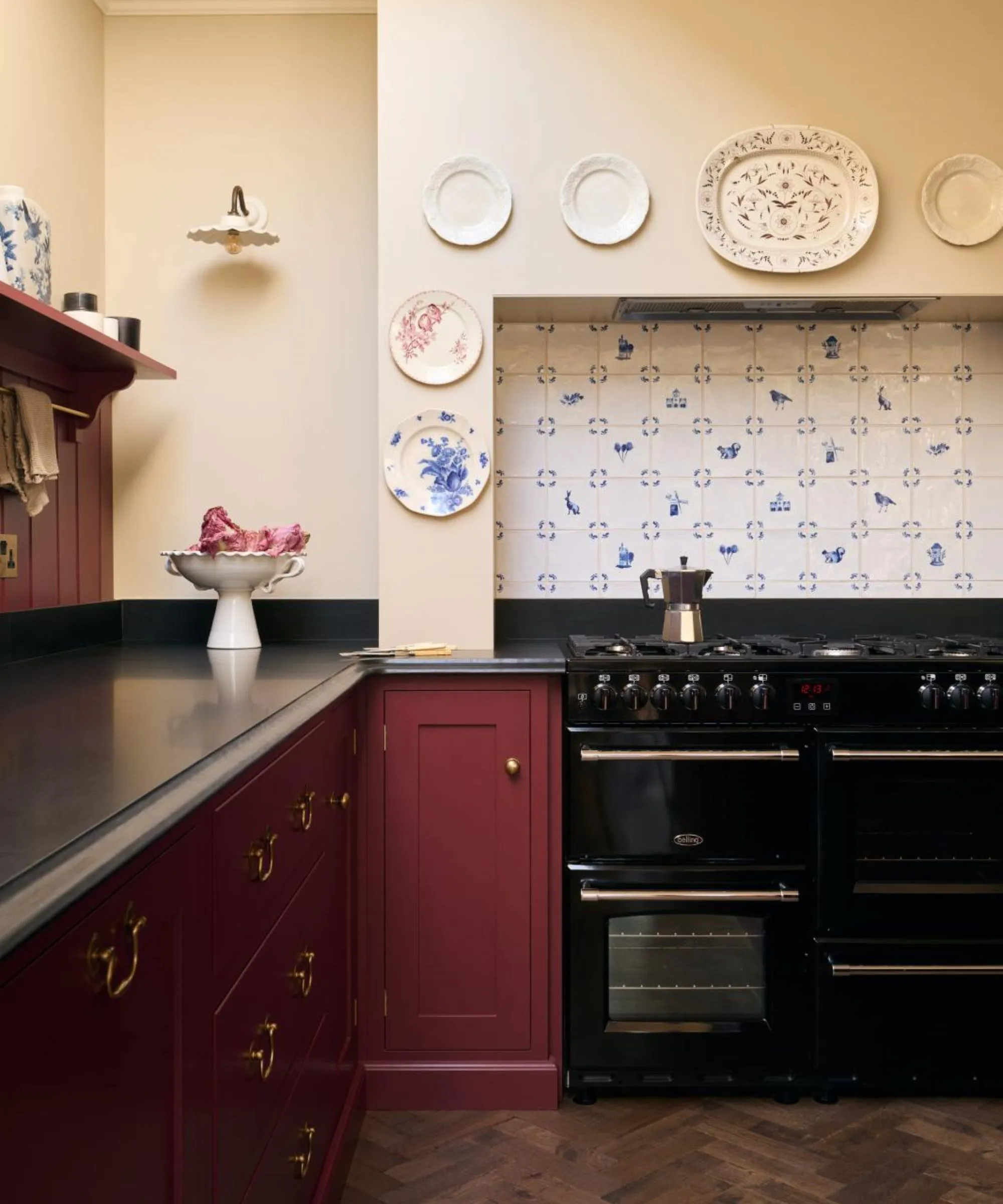 Kuchynská trepačka v štýle vintage natretá v bordovej červenej farbe s veľkým sporákom a digestorom obložená vintage dlaždicami Delft' loading='lazy' title=