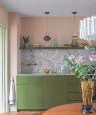 Kjøkken med grønne skap og rosa vegger