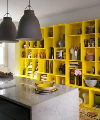 Um exemplo de ideias de prateleiras de cozinha mostrando um grande armário de cozinha amarelo com prateleiras abertas