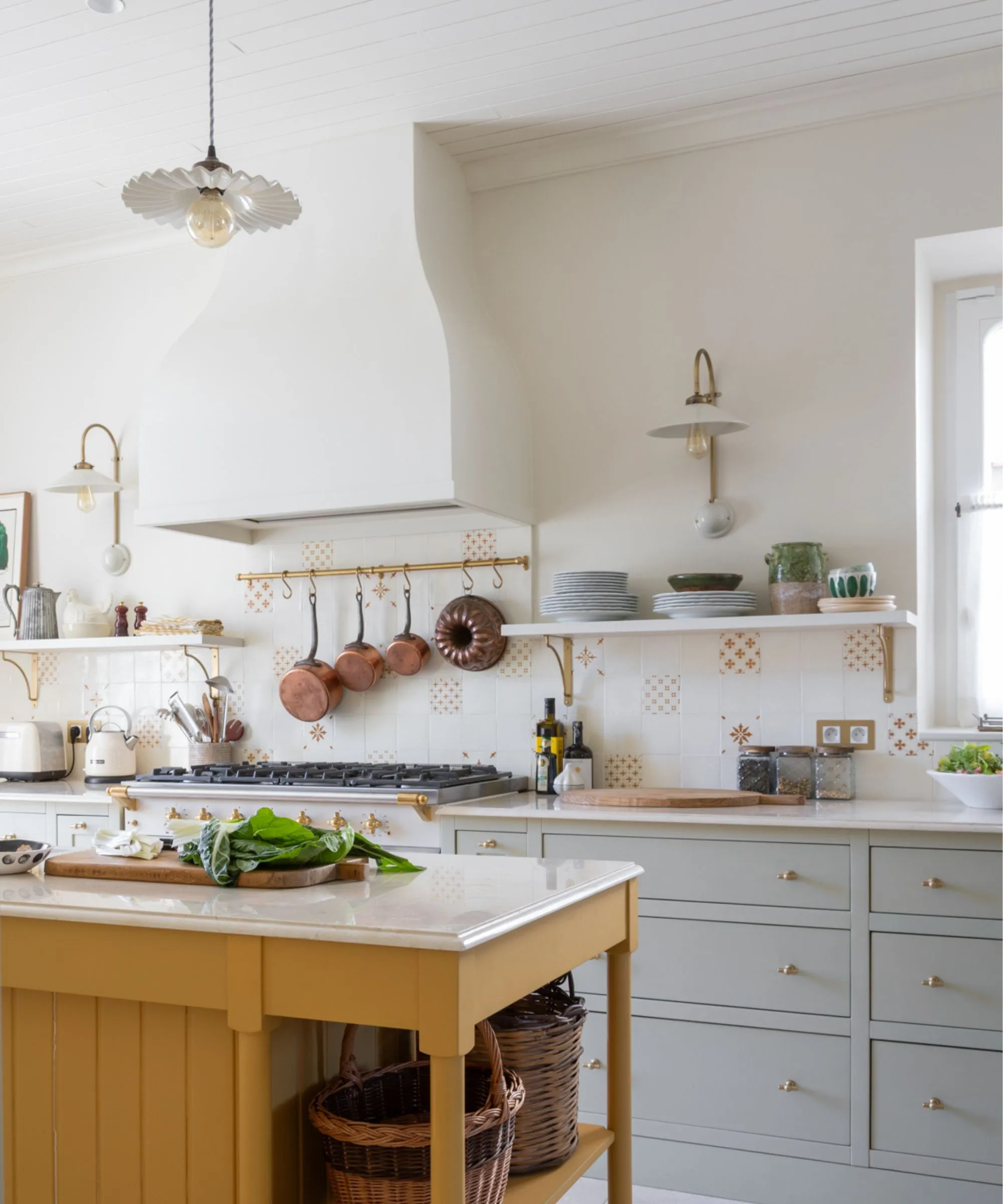 Offene Küche mit blauer Kochinsel und Blick auf einen Wohnbereich mit Steinverkleidung und Vintage-Möbeln' loading='lazy' title=