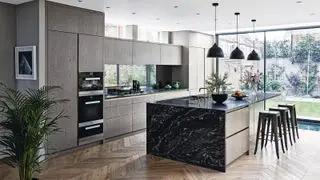 Ampliación de cocina moderna equipada con paredes con efecto de madera gris y isla de cocina de mármol negro sobre suelo de parquet