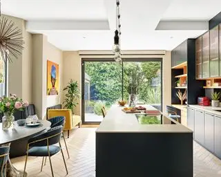 Cocina abierta con suelo de madera y zona de escritorio.