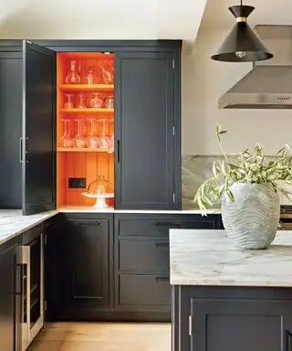 Cocina gris con gabinetes pintados de naranja.