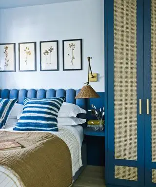 chambre bleue avec lit double, œuvres d'art et armoire recouverte de rotin