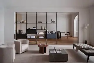Sala de estar contemporânea com tons suaves, estantes em plano aberto e assentos modernos