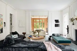 Sala de estar moderna em plano aberto com chaise longue, sofá e cadeiras modernas ao redor de uma lareira