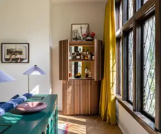 Soggiorno color crema con tende gialle e bar in casa