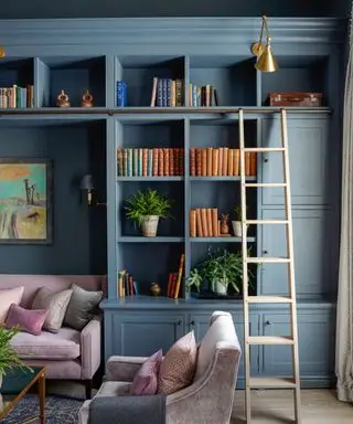 Mobili blu su misura, scala in legno, decorati con libri, piante e ornamenti