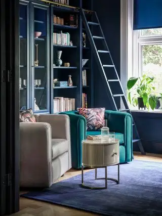 piccola tana con poltroncine e libreria con scalette