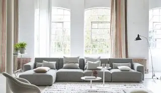 sala de estar branca com seção cinza, console, mesas laterais, tapete, cortinas listradas